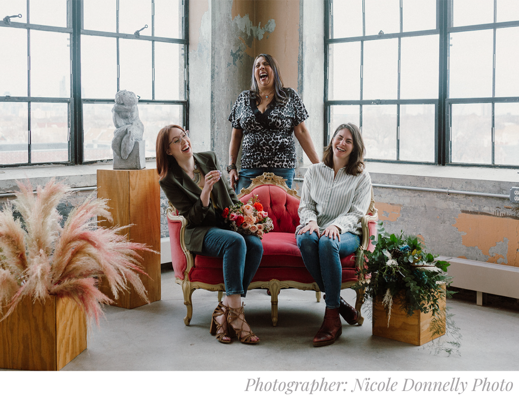 Nicole Donnelly Photography image of Ashland Addison Weddings & Events Staff. Three Wedding & Events Stylists are sitting on a couch, laughing.